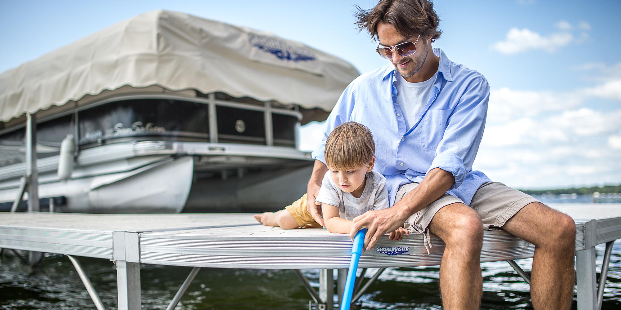 Father sitting on dock with baby