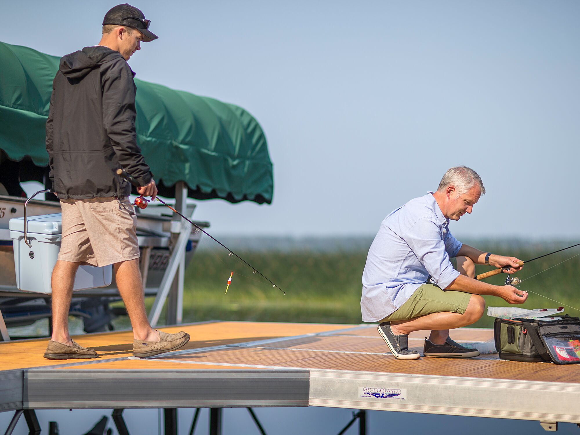 A man sitting on a dock with a fishing rod