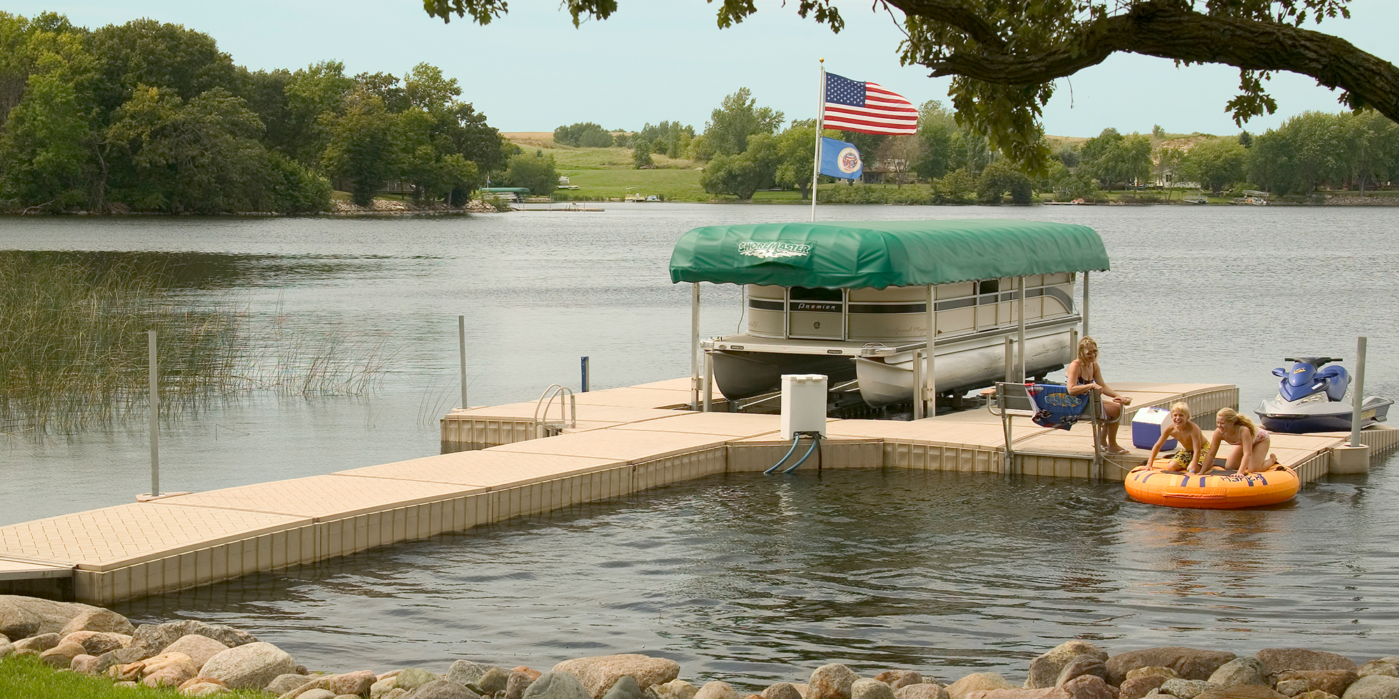 a group of people sitting on a dock next to a body of water